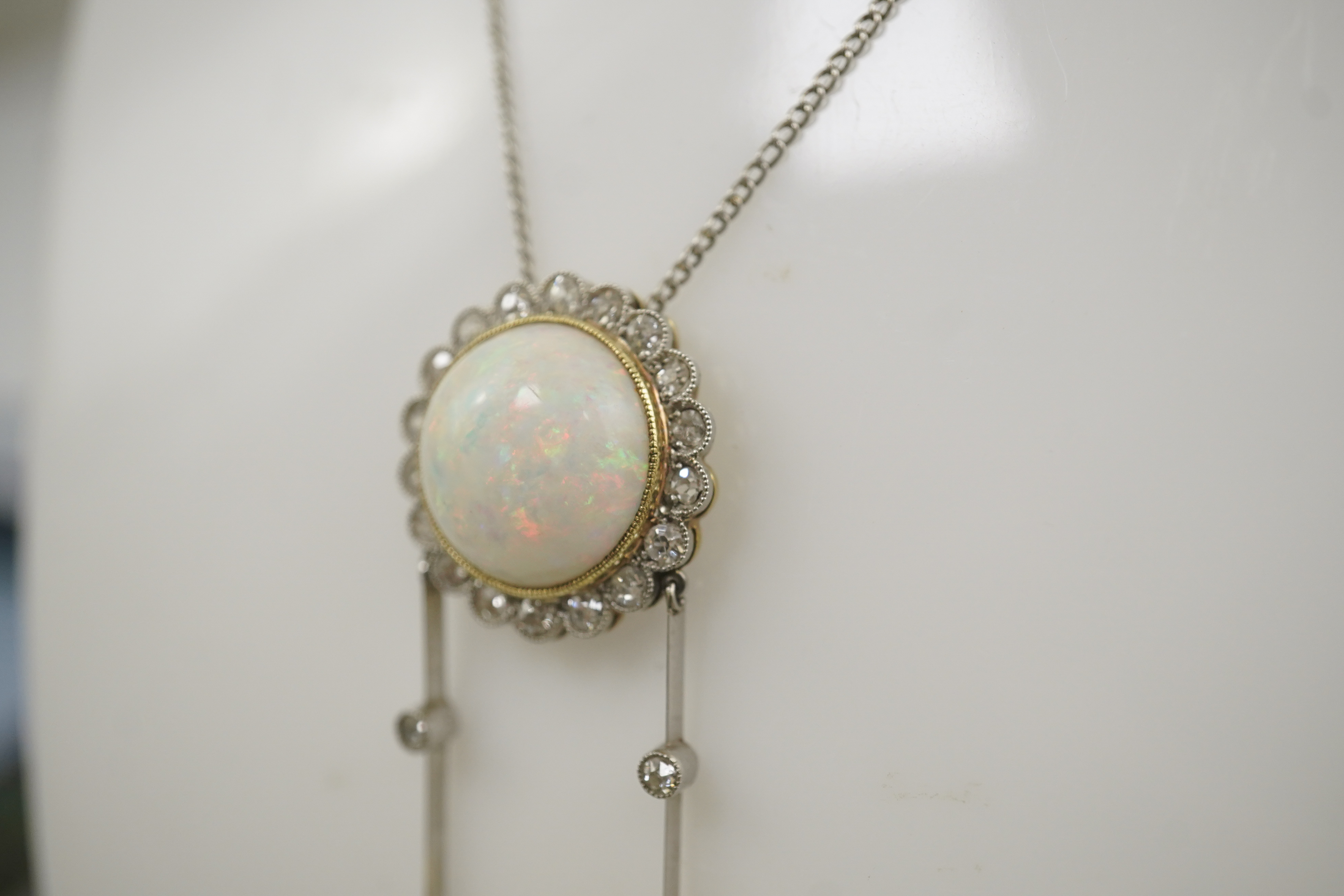 A Belle Epoque platinum and gold, white opal and millegrain set diamond double drop pendant necklace, the chain by Child and Child